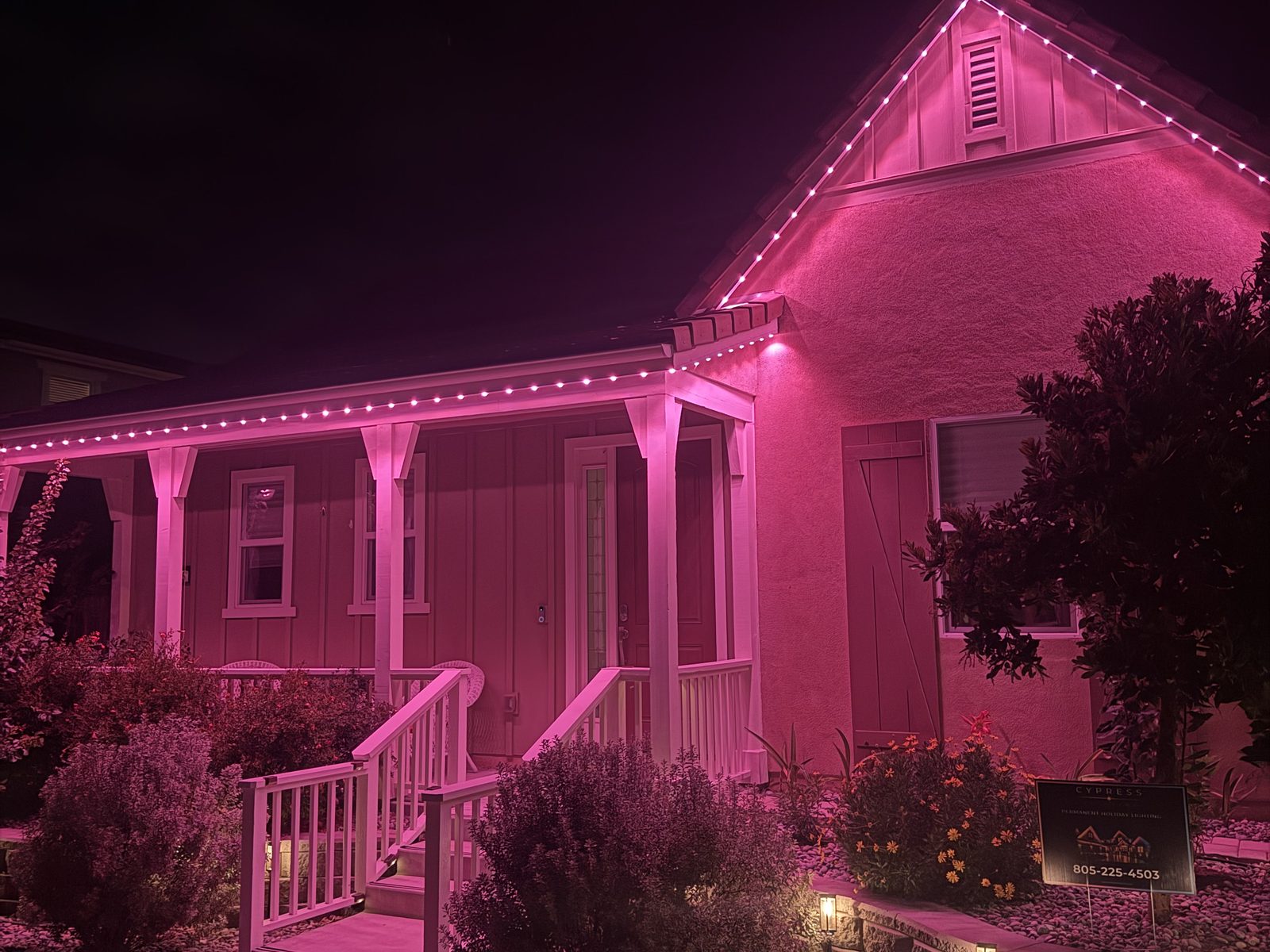 Pink permanent LED lighting on a porch-front home