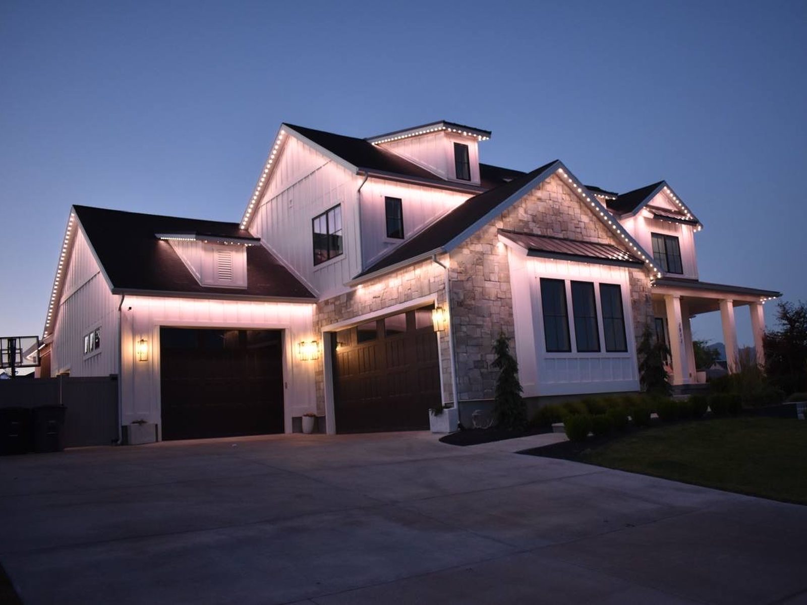 Warm white lighting on a modern farmhouse at dusk