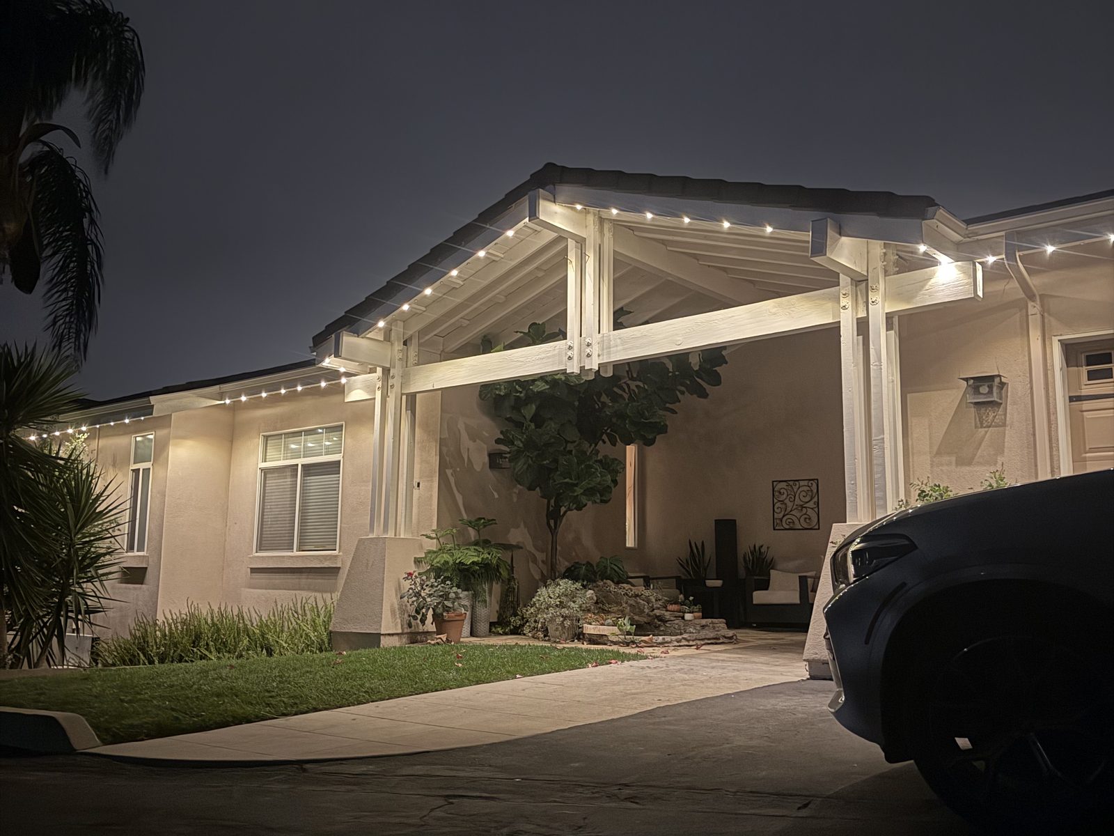 Warm white lighting on a covered entry and roofline
