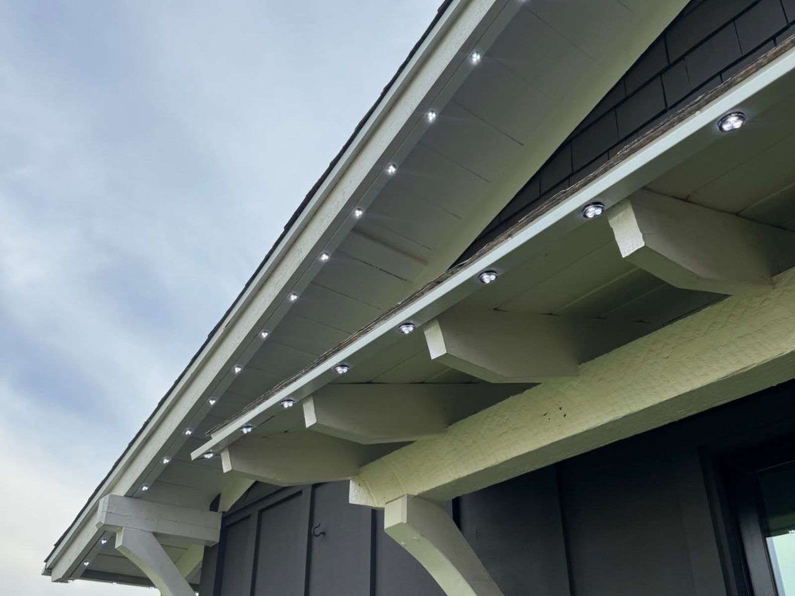 Close-up of permanent track lights under a craftsman eave