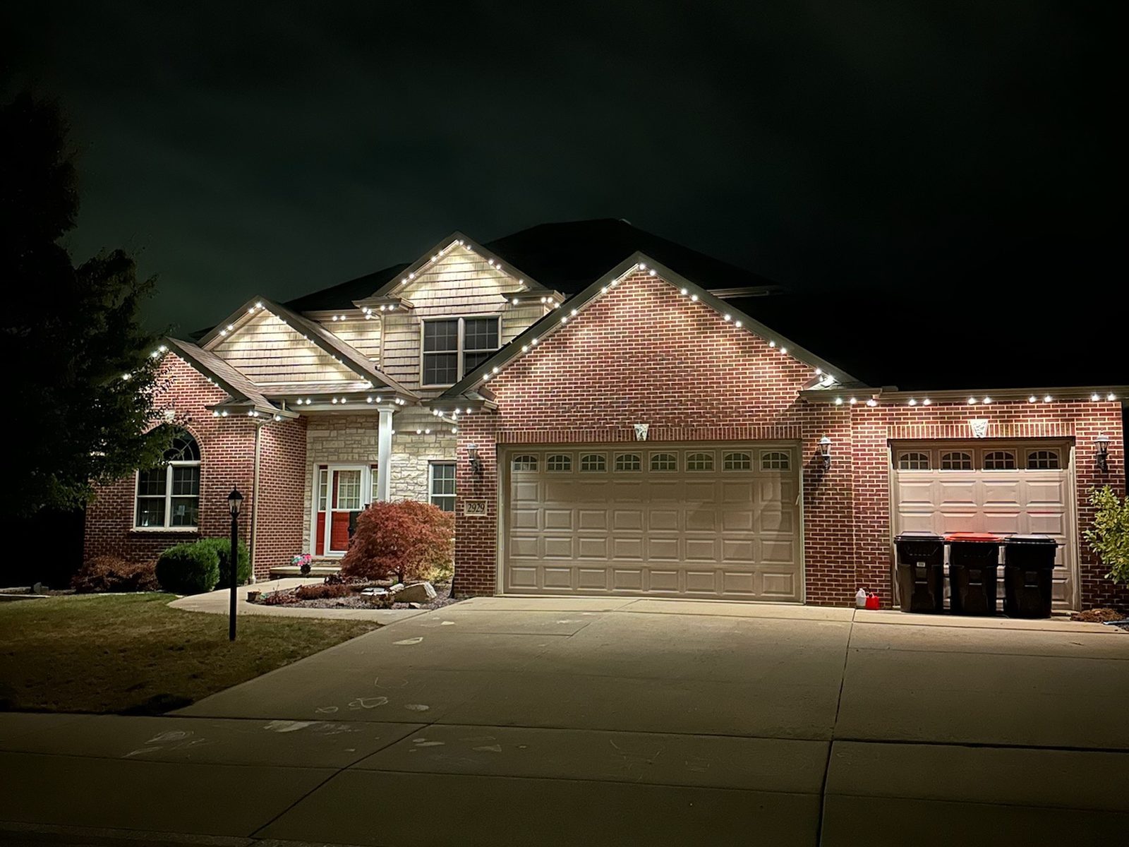 Bright white roofline lighting on a brick home