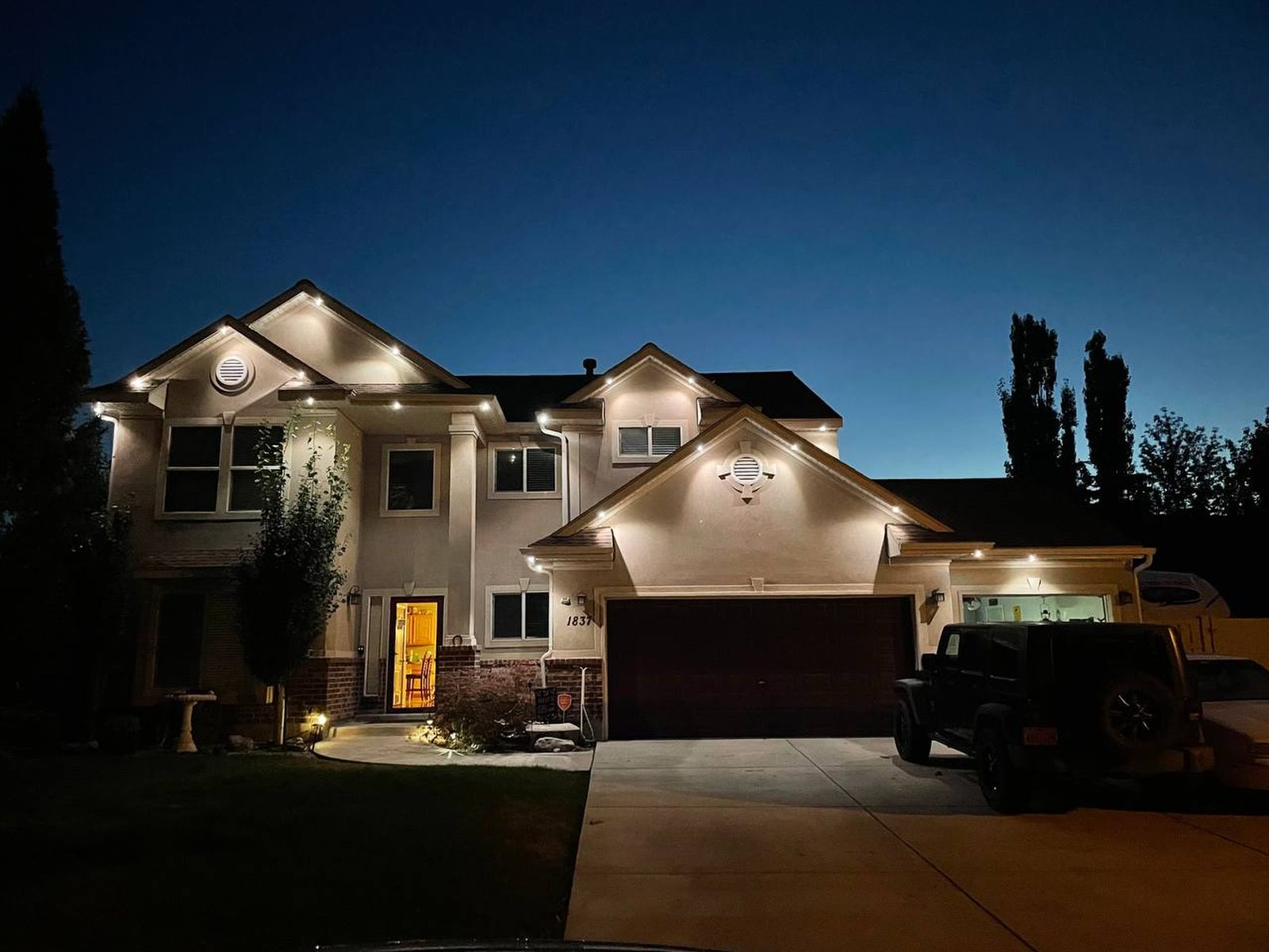Warm white accent lighting on a stucco home at dusk