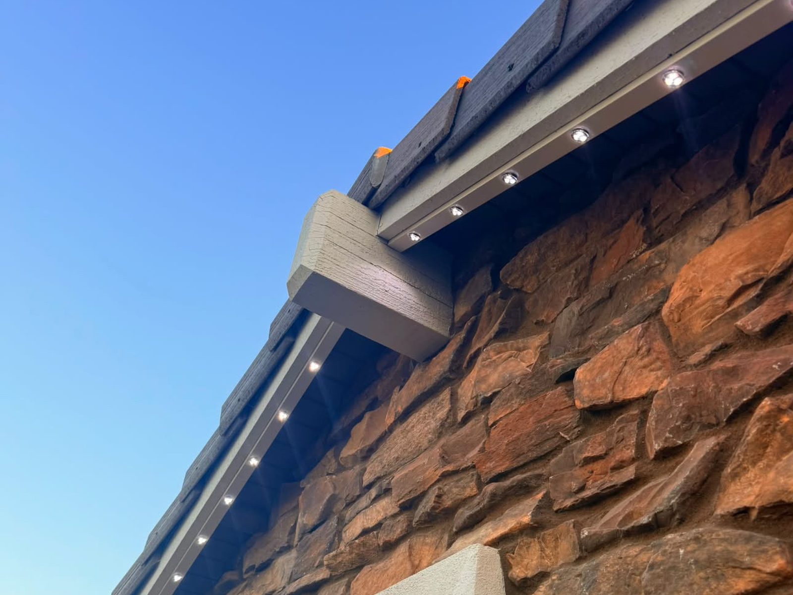 Close-up of lights on a stone-front home at dusk