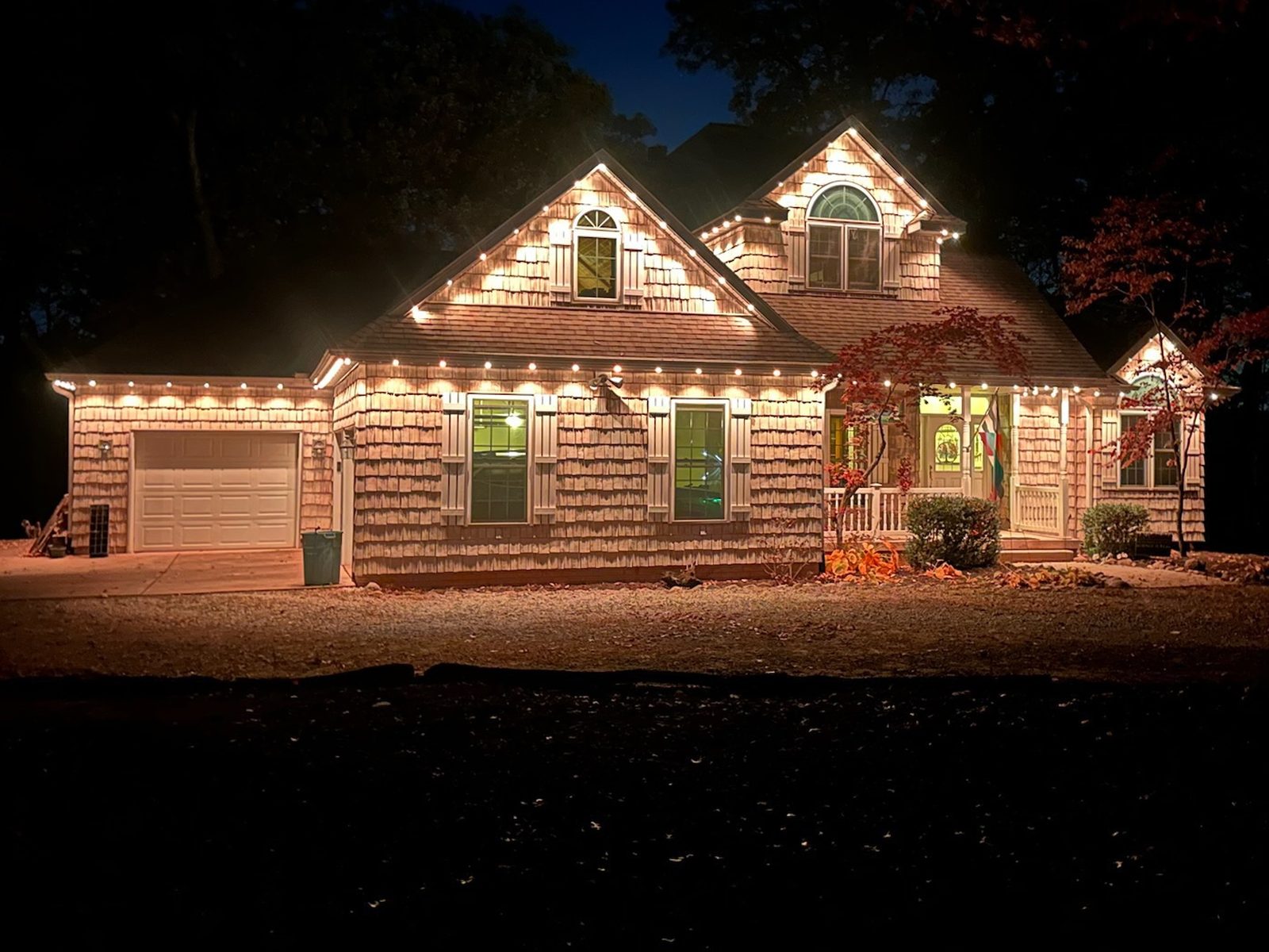Warm white lighting on a shingle-sided home