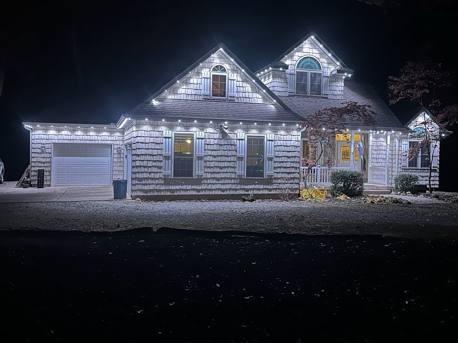 Cool white lighting on a shingle-sided home