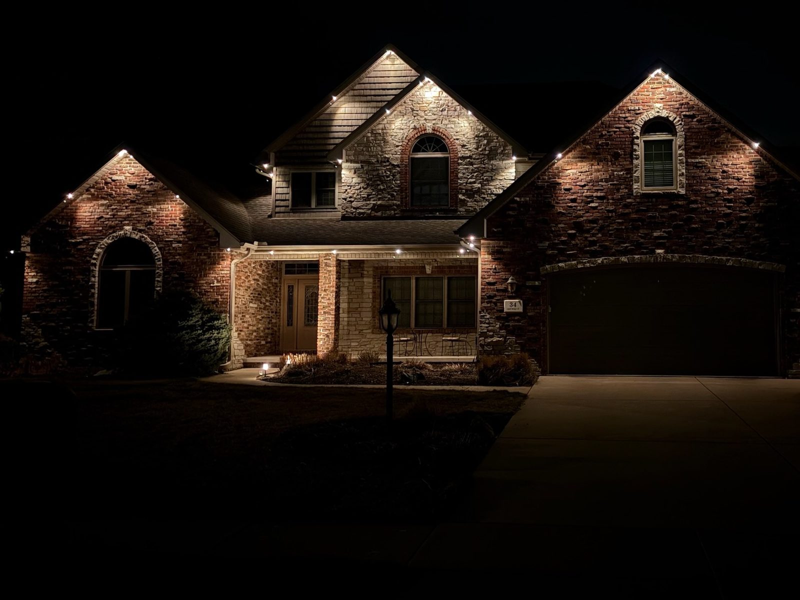 Soft warm white lighting on a gabled brick home