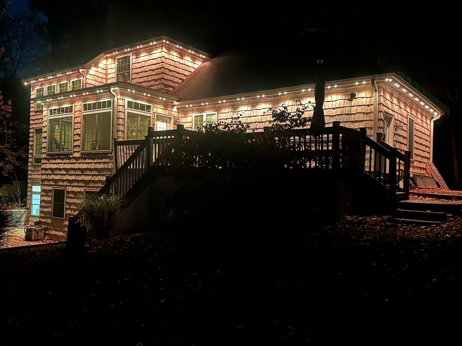 Warm white lighting on the back of a home and deck