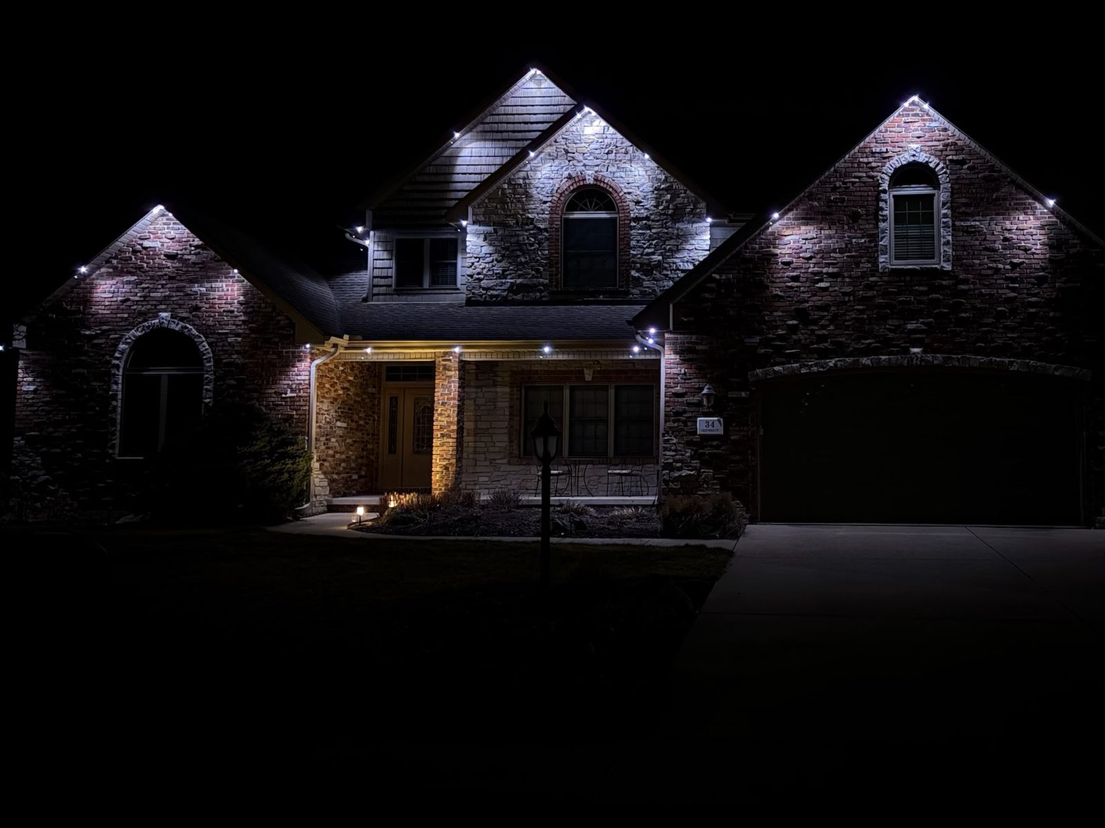 Cool white lighting on a gabled brick home